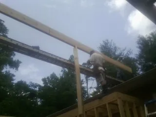 Carpenter setting a ridge beam over a new addition frame — Ice Dam Removal by Roofing Brothers in Lewiston