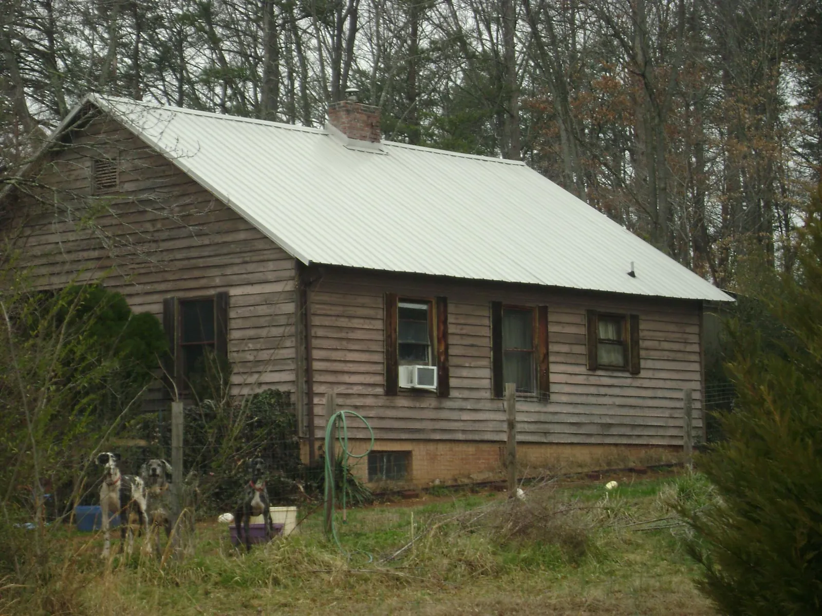 White metal roof on an old wood sided farmhouse, from a Metal Roof Installation job in Lewiston